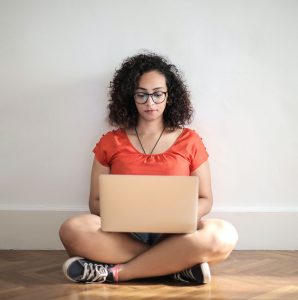 girl with laptop sitting on floor