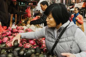 woman choosing produce at a market
