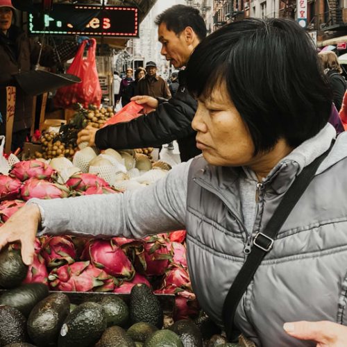 woman choosing produce at a market