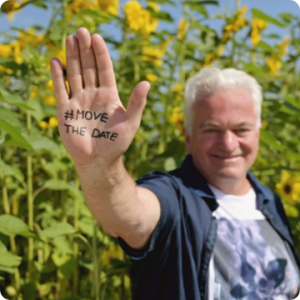 smiling man with #MoveTheDate hand